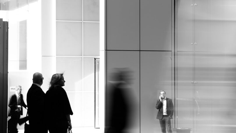 grayscale photo of people walking towards building